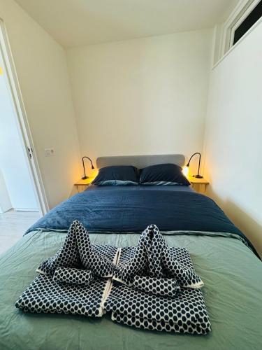 a bedroom with a bed with three pillows on it at Beachhouse Seepaertje - Boulevard Noordwijk aan Zee in Noordwijk aan Zee