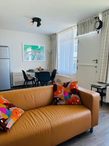 a living room with a couch and a table at Beachhouse Seepaertje - Boulevard Noordwijk aan Zee in Noordwijk aan Zee