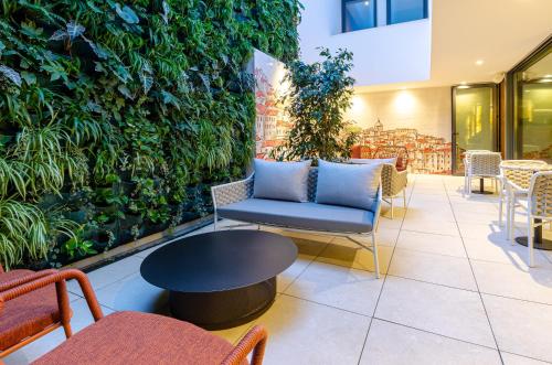 a lobby with a green wall with a blue couch and chairs at TURIM Lisboa Hotel in Lisbon