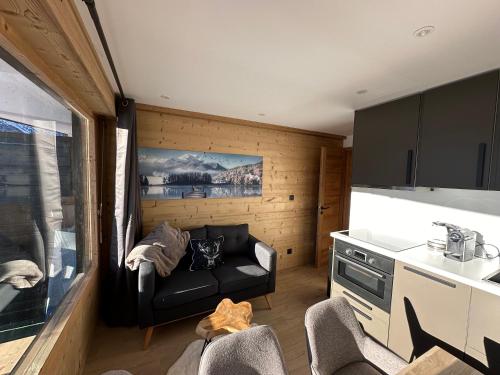 un salon avec un canapé et une cuisine dans l'établissement Appartement rénové cosy avec belle vue, à Montgenèvre