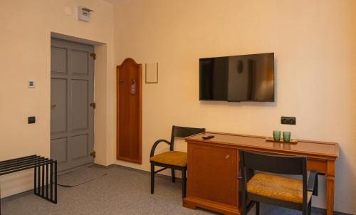 a room with a desk and a television on the wall at Epic rooms in Braşov