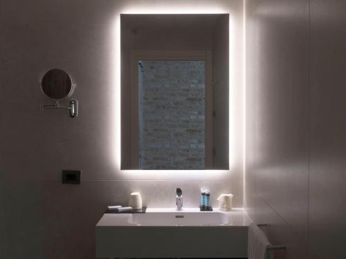 a bathroom with a white sink and a mirror at Hotel Aquarius Venice - Ascend Collection in Venice