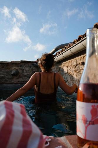 a woman sitting in the water next to a bottle at Casa Comalats in Ametlla