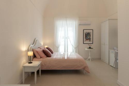 a white bedroom with a bed and a window at Dimora Margherita in Caserta
