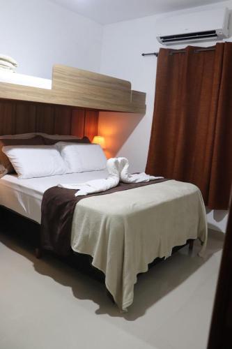 a bedroom with a large bed with avertisement at CONFORTO IMBATIVEL - 25 metros do MAR - 2 Quartos com AR CONDICIONADOS SPLIT, Air Fryer, WI-FI, Disney Plus, Star Plus, HBO Max, Guarda Sol, Cadeiras de Praia e Caixa Térmica - 8 pessoas com Muito Conforto - Melhor Localização! in Guarapari