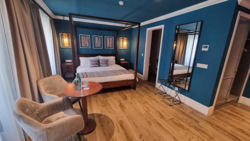 a bedroom with a bed and a table and a mirror at Açores Autêntico Boutique Hotel in Angra do Heroísmo