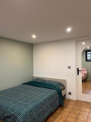 une chambre avec un lit et un miroir dans l'établissement Maison Arnouville 15 mins CDG Airport 20 mins Paris, à Arnouville-lès-Gonesse