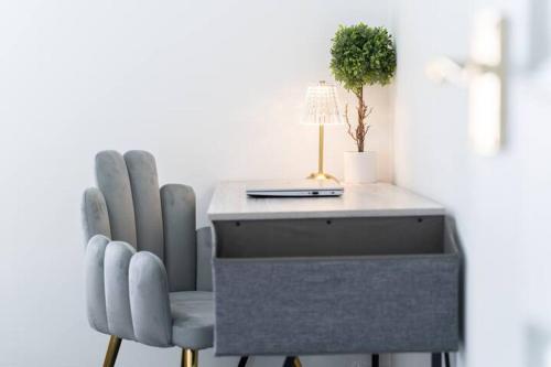 a desk with two chairs and a lamp and a plant at Open Mind Property - Luxury House & Free Parking in Portsmouth