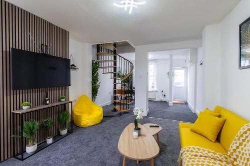 a living room with a yellow couch and a table at Open Mind Property - Luxury House & Free Parking in Portsmouth