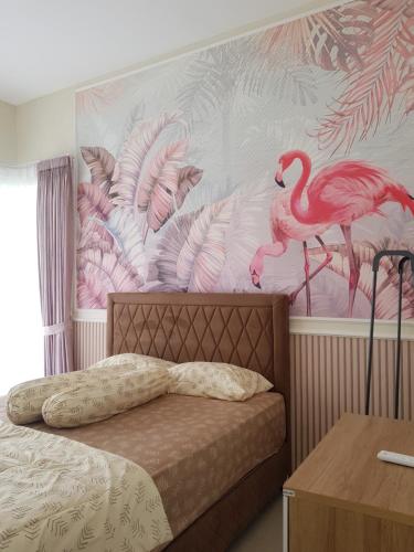 a bedroom with a mural of flamingos on the wall at Villa Neona Nora in Tlekung