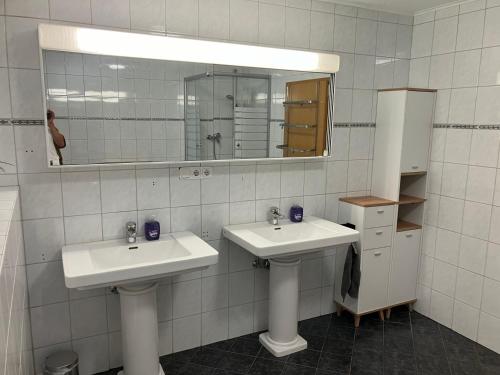 un bagno bianco con due lavandini e uno specchio di 4 Schlafzimmer Apartment a Neustadt