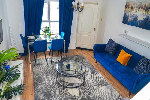 a living room with a blue couch and a table at Milton Keynes Home - Sleeps 4 - Parking in Milton Keynes
