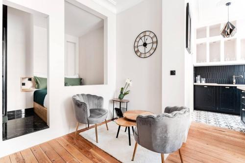 un salon avec une table et des chaises et une chambre dans l'établissement Le 107 - Appartement haut de gamme à Chinon, à Chinon