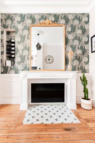 un salon avec une cheminée et un miroir dans l'établissement Le 107 - Appartement haut de gamme à Chinon, à Chinon