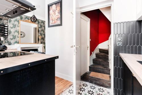 une cuisine avec des murs rouges et blancs et un escalier dans l'établissement Le 107 - Appartement haut de gamme à Chinon, à Chinon