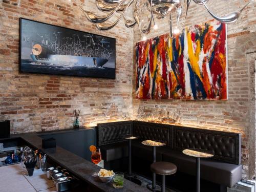 a restaurant with a brick wall with paintings on the wall at Hotel Aquarius Venice - Ascend Collection in Venice