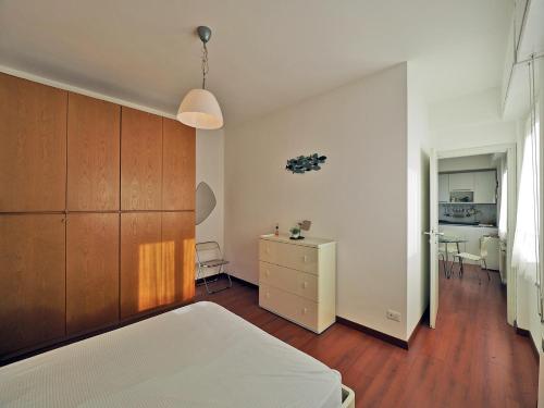 a bedroom with a bed and a dresser and a kitchen at Finestra Sul Mare in San Terenzo