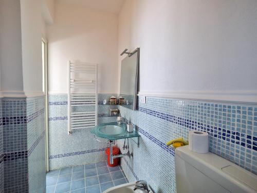 a blue tiled bathroom with a sink and a mirror at Finestra Sul Mare in San Terenzo