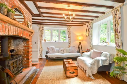 a living room with two couches and a fireplace at 1 Apse Castle Cottage - Chocolate Box Cottage, Pet-Friendly 16th Century Cottage, surrounded by Ancient Woodland in Shanklin in Shanklin
