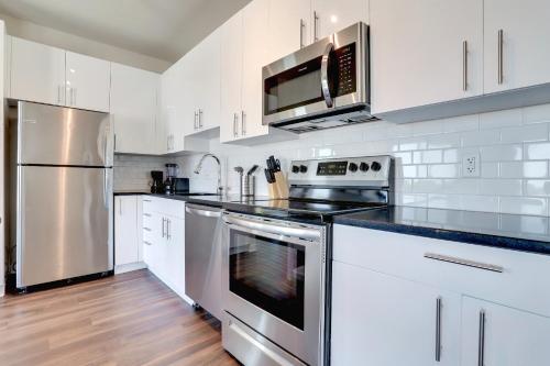 a kitchen with stainless steel appliances and white cabinets at Spacious Apt w All Amenities That You Need! in Alexandria