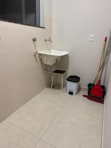 Un baño blanco con un lavabo y una silla. en Top beach flat, en Porto Seguro