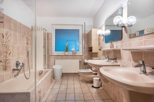 a bathroom with two sinks and a tub and a toilet at Ferienhaus Timm in Meldorf