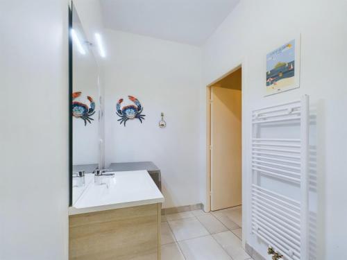 une salle de bain avec un lavabo et un miroir dans l'établissement À 50m de la plage, bel appartement pour 6, à Pléneuf-Val-André