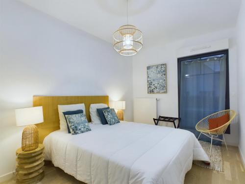 une chambre blanche avec un grand lit et une fenêtre dans l'établissement À 50m de la plage, bel appartement pour 6, à Pléneuf-Val-André