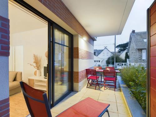 d'une terrasse avec des chaises rouges et une table sur un balcon. dans l'établissement À 50m de la plage, bel appartement pour 6, à Pléneuf-Val-André