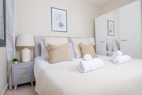 a white bedroom with two towels on a bed at Magnifique 2 pièces rénové aux Sources in Vieux Kouba