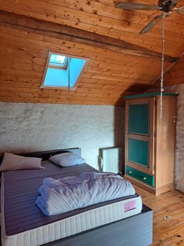 un lit dans une chambre avec un plafond en bois dans l'établissement La Maison de Tigery, à Tigery