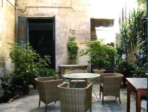 un patio avec une table, des chaises et des plantes dans l'établissement Appartement Petite Saunerie, à Avignon