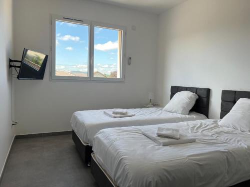 deux lits dans une chambre avec une fenêtre dans l'établissement Maison 40 avec 5 chambres lechaffardcom, à Satolas-et-Bonce