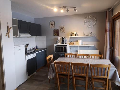 une cuisine avec une table et des chaises dans une pièce dans l'établissement Appartement cosy 6-8pers-2ch-2sdb-Terrasse-Superdevoluy, à Superdevoluy