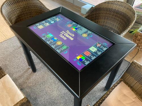 a tablet sitting on top of a table with two chairs at Vulkán Wellness Hotel & Camping in Celldömölk