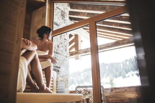 a woman sitting on a window sill at Lech Lodge - LEGENDARY in Lech am Arlberg