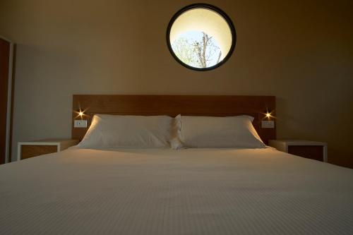 a bedroom with a large bed with a mirror above it at JATU Retreat in San Costantino