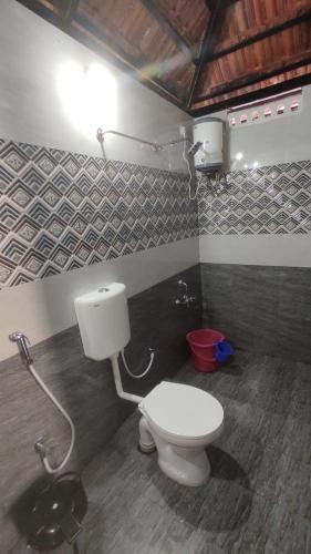 a bathroom with a white toilet in a room at Auro Coastal Haven in Pondicherry
