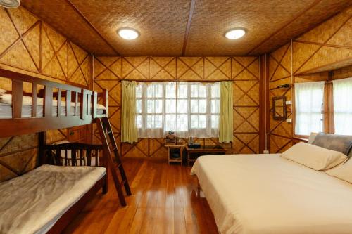 a bedroom with two bunk beds and a desk at Ashi Guesthouse Chiangdao in Chiang Dao