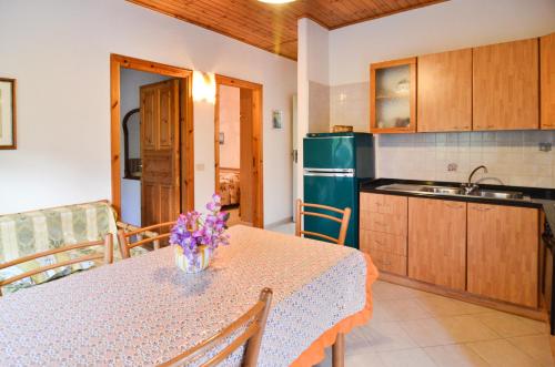 a kitchen with a table with a vase of flowers on it at Residence Limoneto Ischia in Ischia