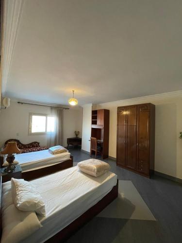 a hotel room with two beds and a desk at The Grand Penthouse in Cairo