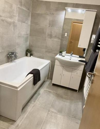 a bathroom with a bath tub and a sink at Suite Luxueuse et moderne - Séjournez chez nous in El Aouina