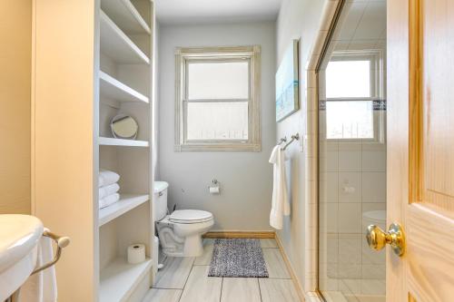 a bathroom with a toilet and a shower and a window at Spacious Cabin with Views, Near Lake Lawtonka! in Medicine Park