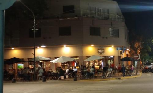 a group of people sitting outside of a restaurant at night at Hotel Bonino in Villa Mercedes