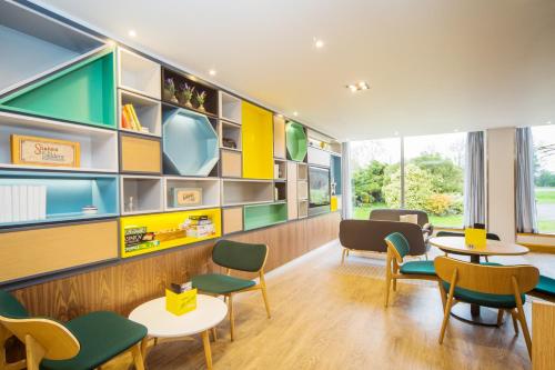 a childrens waiting room with tables and chairs at Holiday Inn London - Gatwick Airport by IHG in Horley