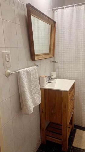 a bathroom with a sink and a mirror at Bella Casa La Costa in Santa Teresita