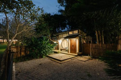 a small house with a clock on the side of a fence at Ashi Guesthouse Chiangdao in Chiang Dao