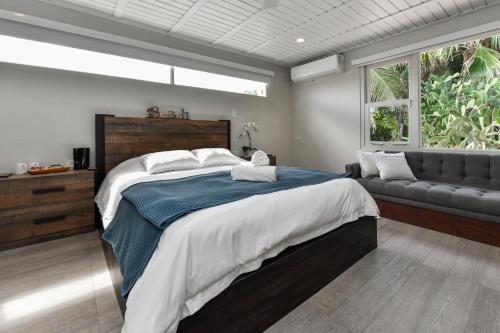 a bedroom with a large bed and a couch at Aloe B&B in Oranjestad
