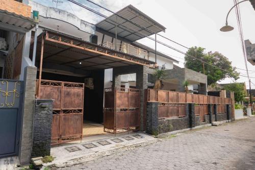 a building with wooden doors on a street at Jati Lawas Homestay Jogja by Anvia in Ngabean