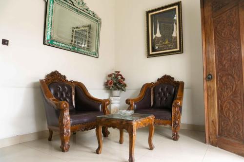 two chairs and a coffee table in a room at Jati Lawas Homestay Jogja by Anvia in Ngabean